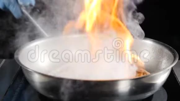 不可辨认的厨师把热的不粘煎锅与海鲜然后点燃它烹饪火焰菜慢慢视频的预览图