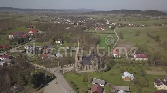 波兰西克林72019年罗马天主教会在一个风景如画的村庄的中心位于青山上空中无人机或q视频的预览图