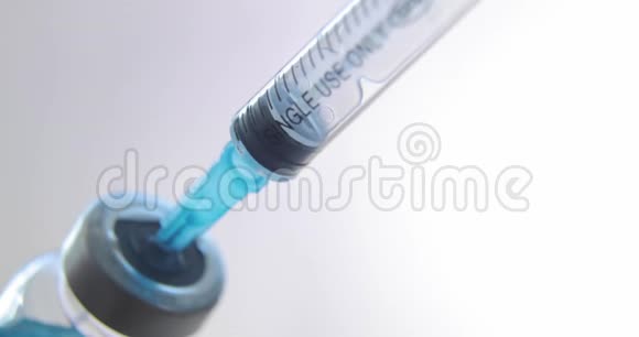 在光背景下将蓝色冠状病毒SARS流感疫苗注射到注射器中视频的预览图