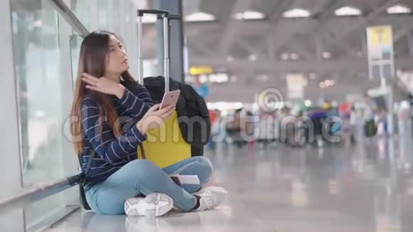 年轻女性旅行者在等待某人时使用智能手机视频的预览图