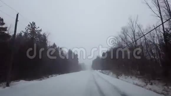 在冬季暴风雪中驾驶农村常绿森林道路司机视角POV雪雪暴雪视频的预览图