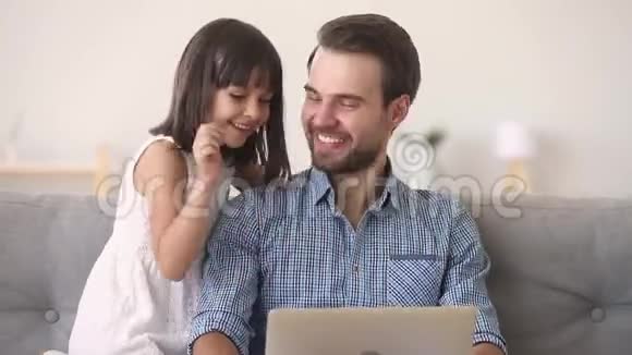 爸爸和女儿在网上玩音乐用电脑视频的预览图