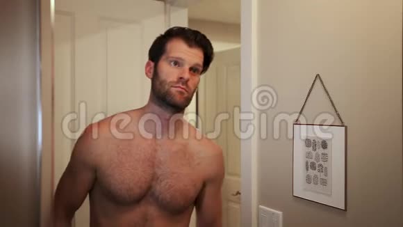 英俊的年轻白种人看着自己在浴室的镜子同时欣赏他的胡须和脸高清24FPS视频的预览图