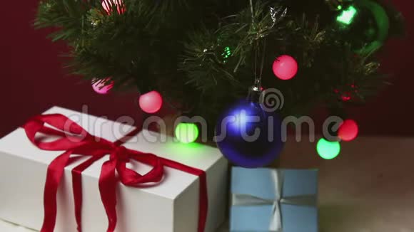 那个年轻人手从圣诞树下拿一件小礼物视频的预览图