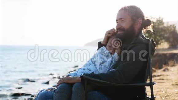 可爱的女孩坐在她父亲的手中他们拥抱和享受视频的预览图