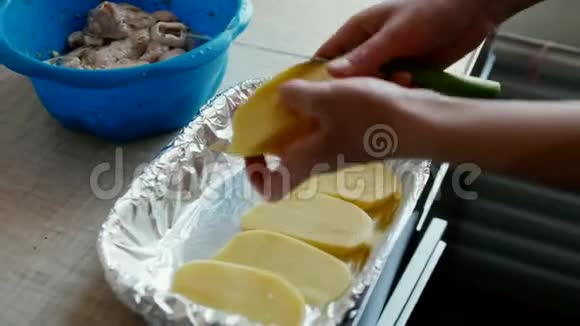 年轻的家庭主妇切一个大土豆放在烤盘上视频的预览图