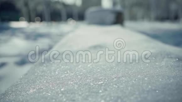在冬季城市公园的雪凳上近距离拍摄了嗖嗖和雪花视频的预览图