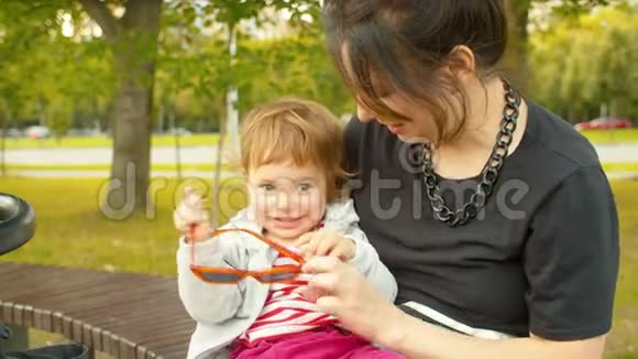 小女孩在妈妈膝盖上玩耍视频的预览图