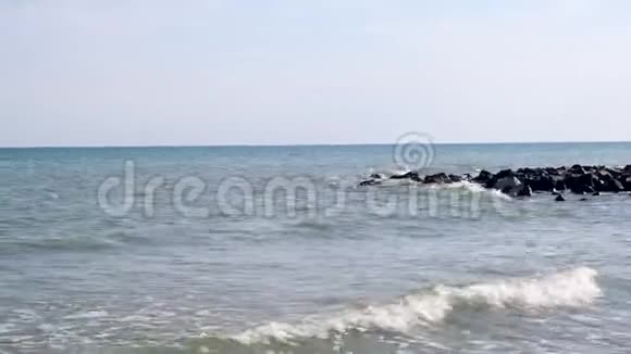 黑海海岸有大石头海浪在阳光明媚的夏日四周飞溅黑海视频的预览图