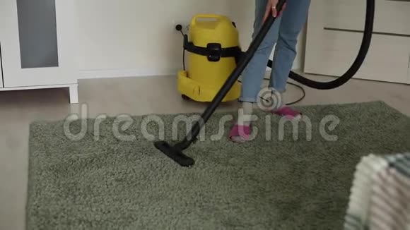 女人在家里用吸尘器清理地板和地毯清除细菌视频的预览图