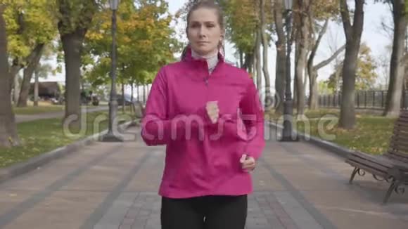 漂亮的高加索女人穿着粉红色运动服因为胸痛而在跑步时停下来女跑步者感觉不好视频的预览图