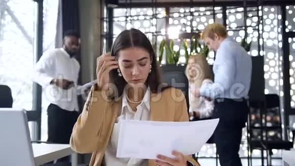 两位年轻有魅力的女企业家在现代办公场所与财务报告和平板电脑合作视频的预览图