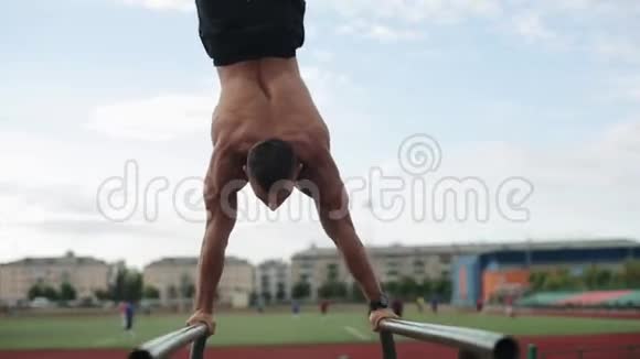 近距离观看一个赤膊肌肉运动员在运动场上做体重俯卧撑模糊的观点视频的预览图