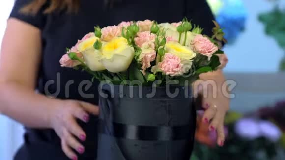 花商女士在店里用黑色盒子包装玫瑰花束特写视频的预览图