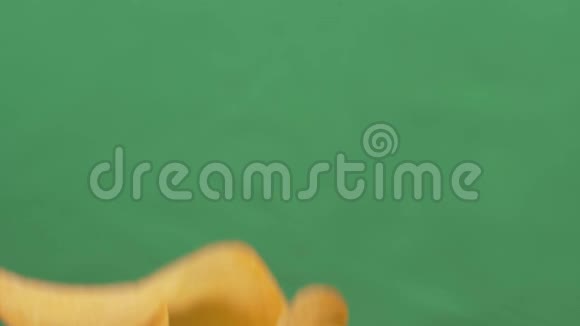 薯片自由落在绿色背景上慢动作采购品视频的预览图