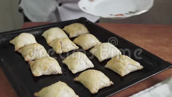 女性手的特写从盘子上的烤盘上铺出热甜百吉饼和面包视频的预览图