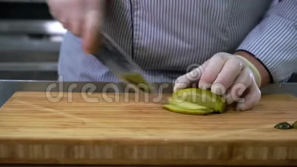 厨师戴橡胶手套用刀在木竹砧板上切腌黄瓜视频的预览图