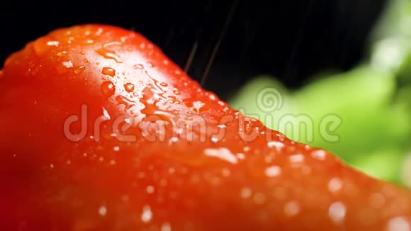 特写视频水滴在黑色背景下慢慢落在红色的辣椒上健康营养概念视频的预览图