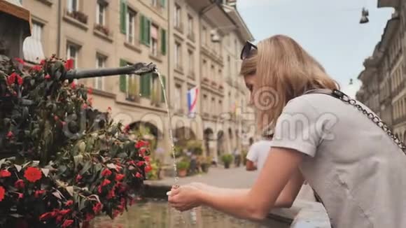 这个女孩正在伯尔尼街上的一个饮水机旁喝酒瑞士视频的预览图