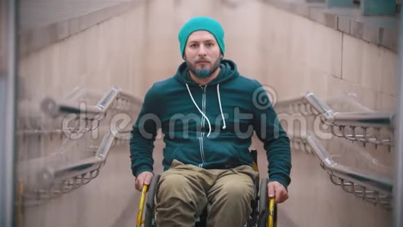 坐轮椅的残疾人微笑着展示他的轮椅的机会在两侧移动靠在上面视频的预览图