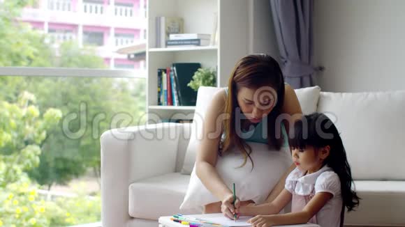 年轻的母亲教可爱的女儿画画视频的预览图