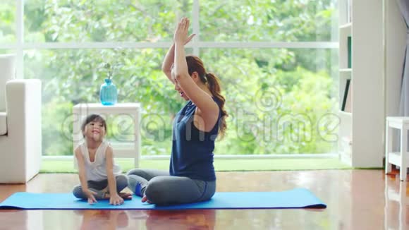 年轻的母亲正在为女儿教授基本的瑜伽姿势视频的预览图
