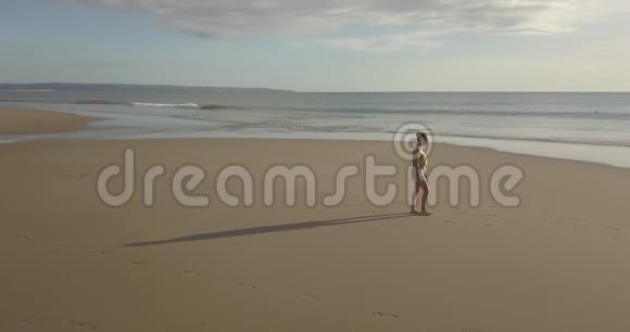 海滩漫步的女性的鸟瞰图视频的预览图