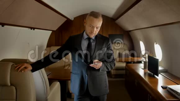吸引人的企业家与智能手机内部的私人飞机视频的预览图