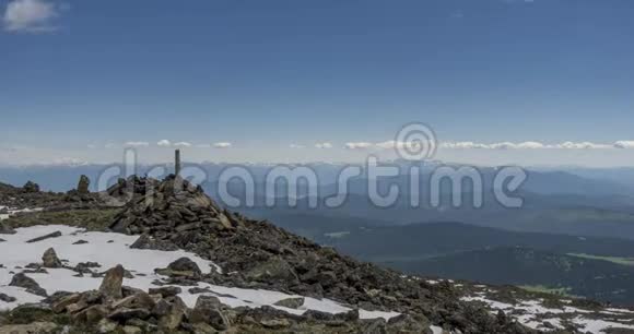 山顶后面云景的时间流逝雪岩石悬崖和深蓝色的天空高空视频的预览图