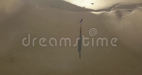 海滩漫步的女性的鸟瞰图视频的预览图
