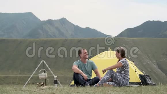在阳光明媚的天气里有爱心的一对夫妇在帐篷前放松在户外玩得开心视频的预览图