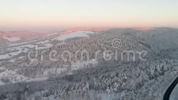 森林覆盖着白雪树木之间有蜿蜒的道路这是全景式的全景拍摄视频的预览图