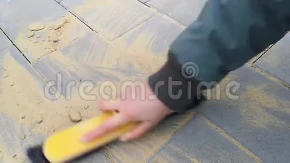 女用刷子刷上11秒用手擦拭新铺砖之间的接缝视频的预览图