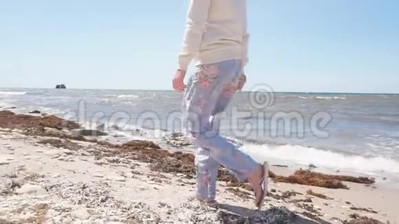 在岩石海岸边行走的女子慢镜头视频的预览图