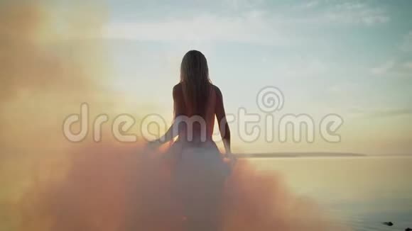 夏天的女孩在水中穿着黎明的背景烟雾中的女孩穿着漂亮的裙子视频的预览图