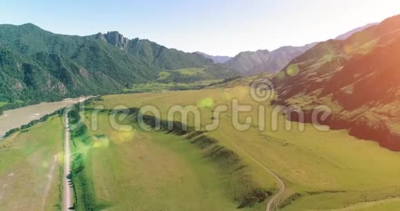 阳光明媚的夏季早晨空中乡村山路和草地沥青公路和河流视频的预览图