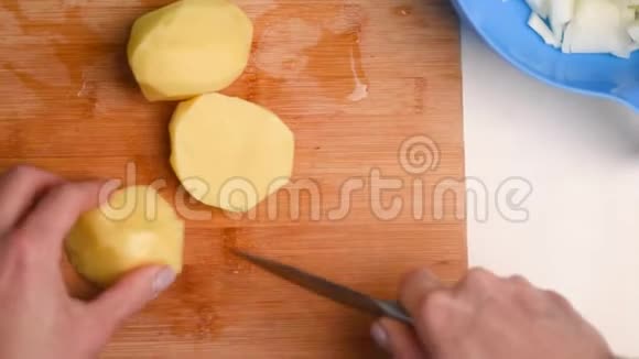 用刀切新鲜蔬菜的手特写女人在白色的切割板特写上切土豆视频的预览图