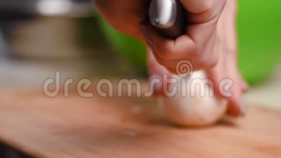 手指上有漂亮指甲的女性用菜刀在蓝色塑料切割板上切割蘑菇视频的预览图