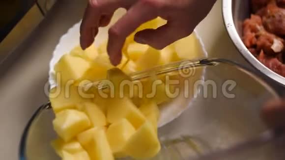就像一个男人把切好的土豆从砧板上放进黄色的碗里视频的预览图