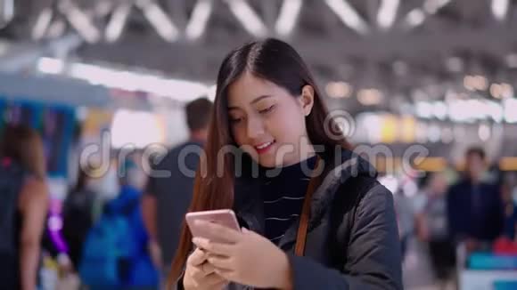 年轻漂亮的女旅行者在机场候机楼用智能手机自拍视频的预览图