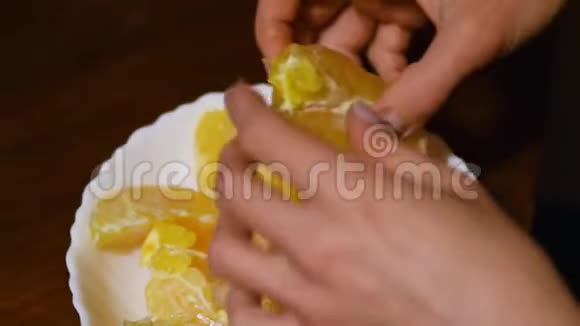 双手慢动作剥柑橘类水果健康食品女手剥橘子皮美味的柑桔片水果视频的预览图