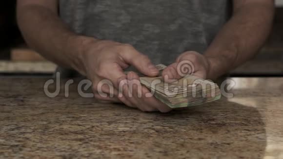 一个年轻人手里拿着钱一个家伙数着他从信封里拿出的加元一个年轻人视频的预览图