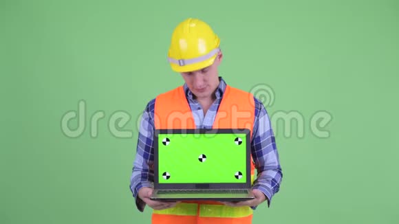 快乐的年轻人建筑工人展示笔记本电脑点头是的视频的预览图