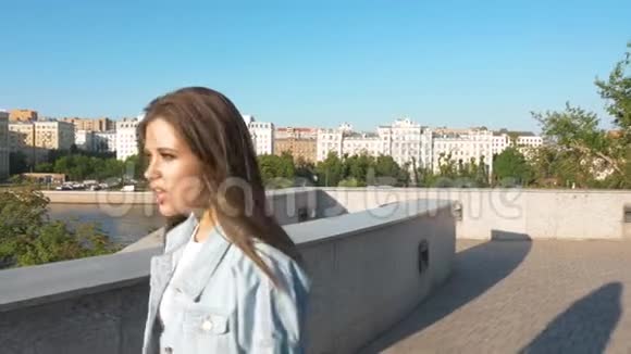 在城市风景中行走的女孩的肖像慢动作视频的预览图