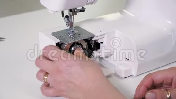 女士在缝纫机中放置带线的穿梭机准备工作双手特写视频的预览图