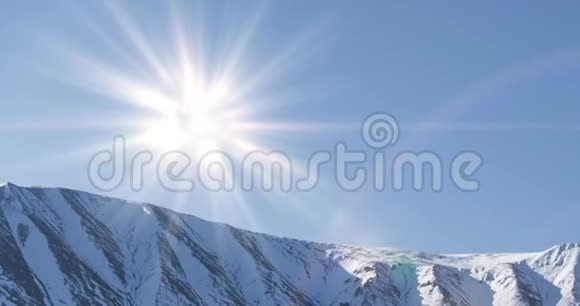 雪山顶上晶莹剔透的天空上太阳运动的时间推移秋天草地上的黄草无边无际视频的预览图