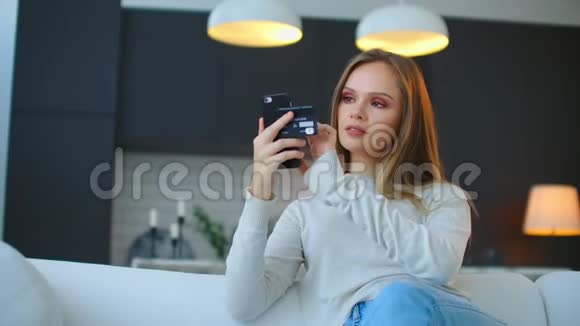 美丽的女性网上银行使用智能手机在线购物与信用卡在家里的生活方式视频的预览图