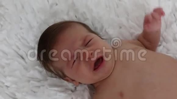 哭泣的婴儿坐在白色的背景视频的预览图