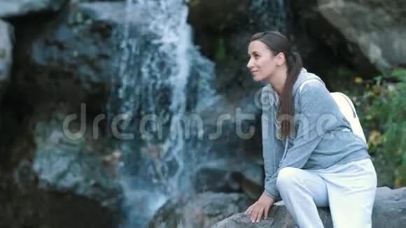 瀑布附近的女人享受大自然视频的预览图