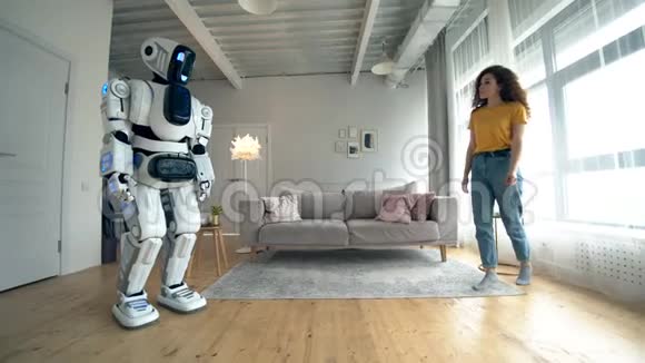 Cyborg和人类概念一个女人摸着白色机器人站在房间里视频的预览图